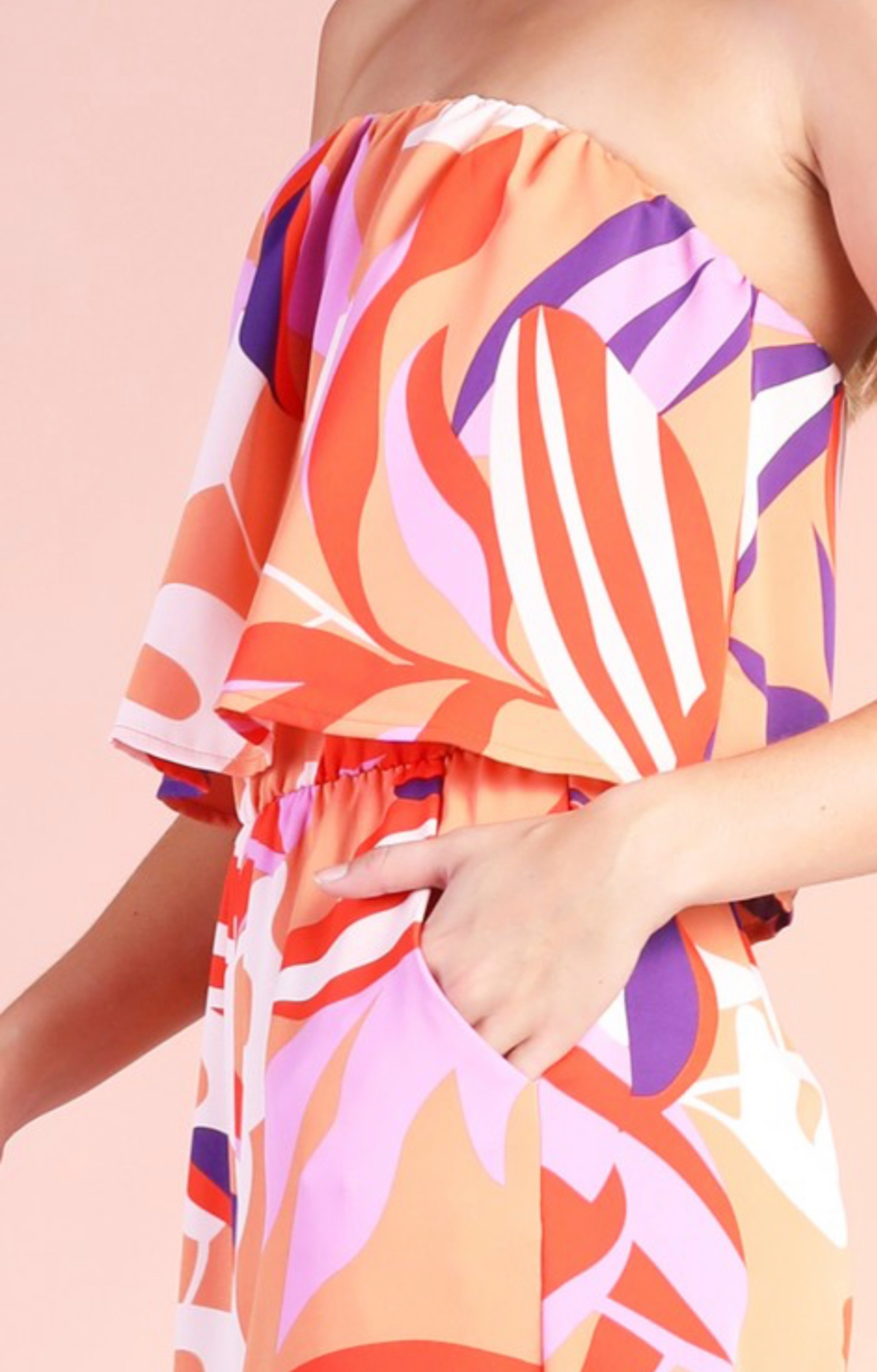 Colorful strapless dress with abstract pattern on a plain background