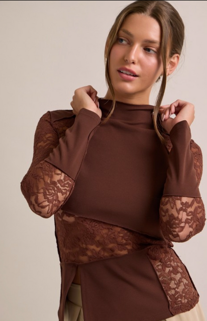 Woman wearing a brown top with lace sleeves against a beige background