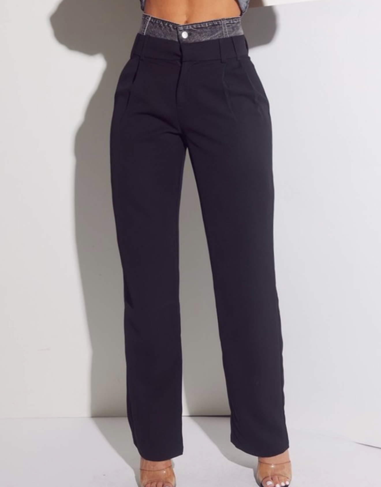 Black pants worn by a person on a white background